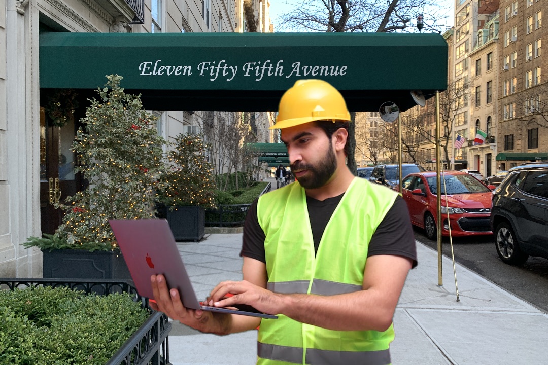 City building inspector using a tablet while examining an apartment building exterior.