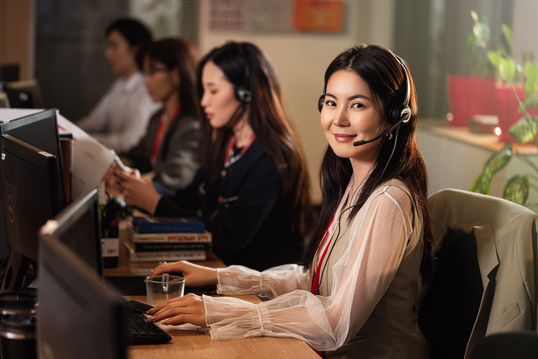 Call center operator with a headset assisting a resident; computer screen shows a help dashboard.