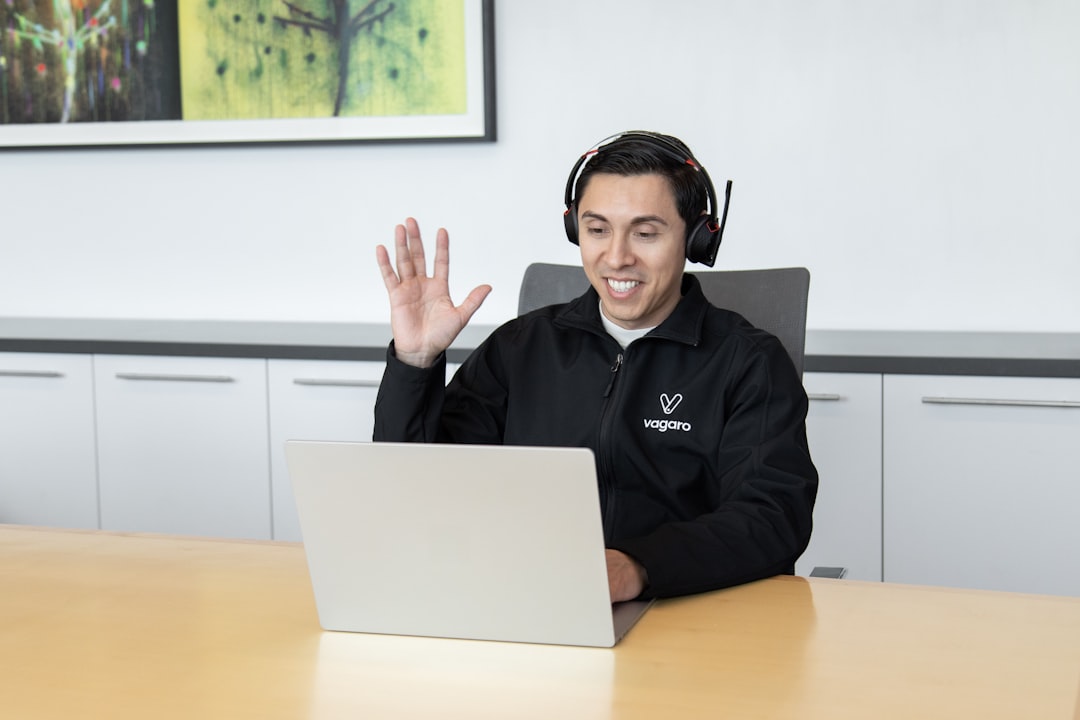 Customer support agent wearing a headset working at a computer in a call center.